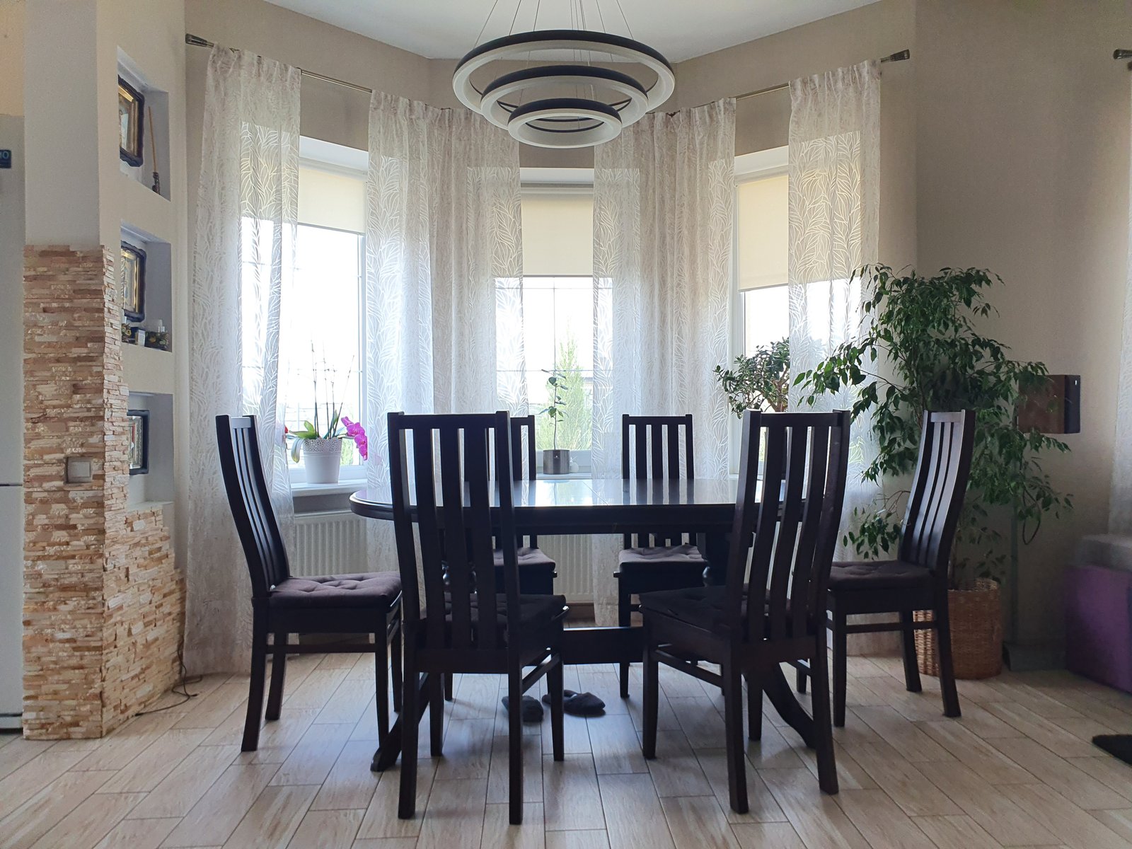 Dining room with sheer curtains and roman blinds
