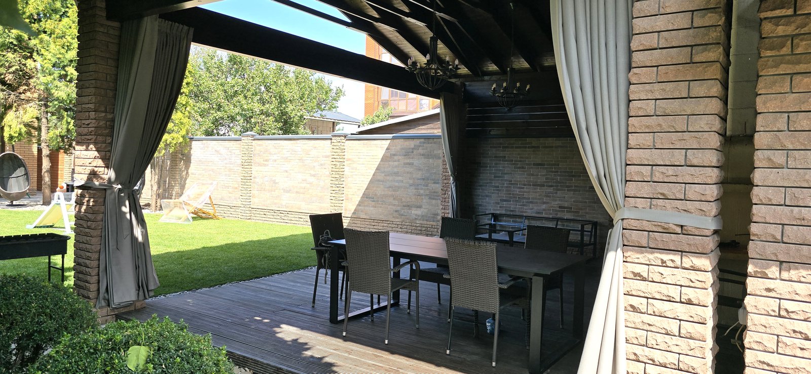 Outdoor terrace with curtains on pergola